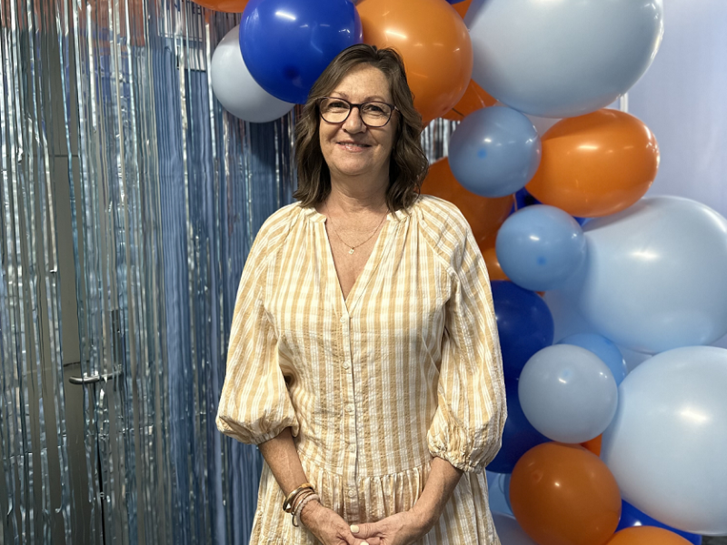 Woman standing with balloons smiling