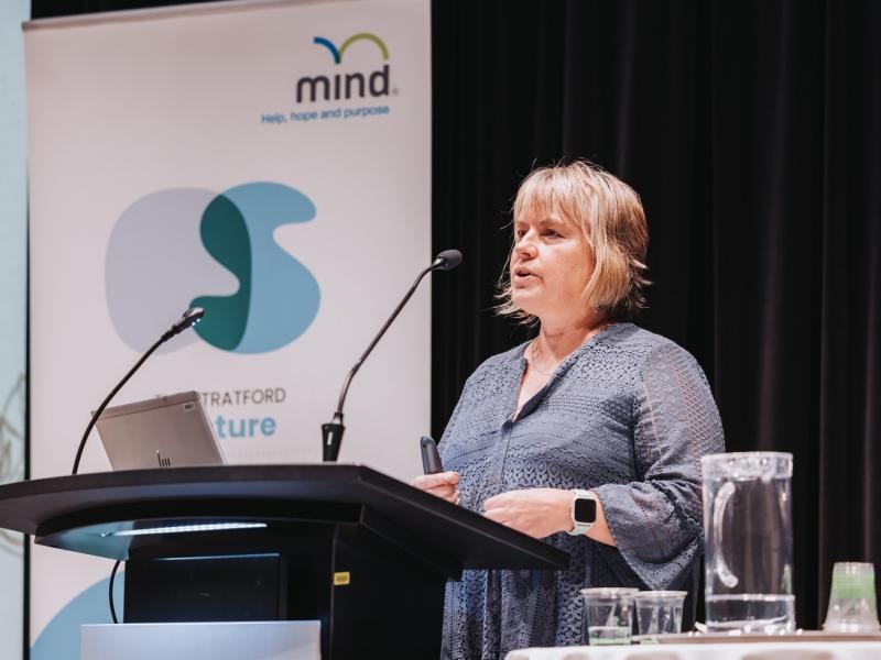 Blonde woman speaking to an audience