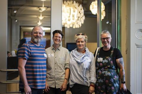 Four people standing and smiling