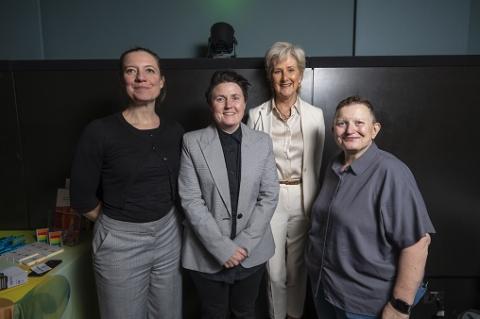 Four women standing and smiling